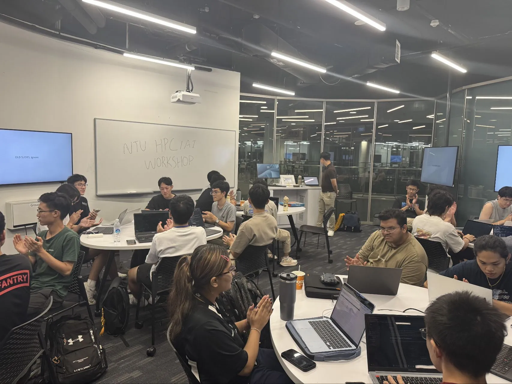 Participants gathered around tables with their laptops during the NTU HPC/AI workshop.